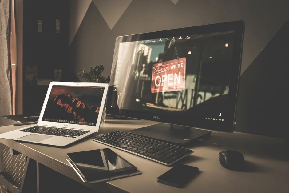 Vue en plongée d'un bureau de travail élégant avec deux écrans, clavier, souris et accessoires contemporains.